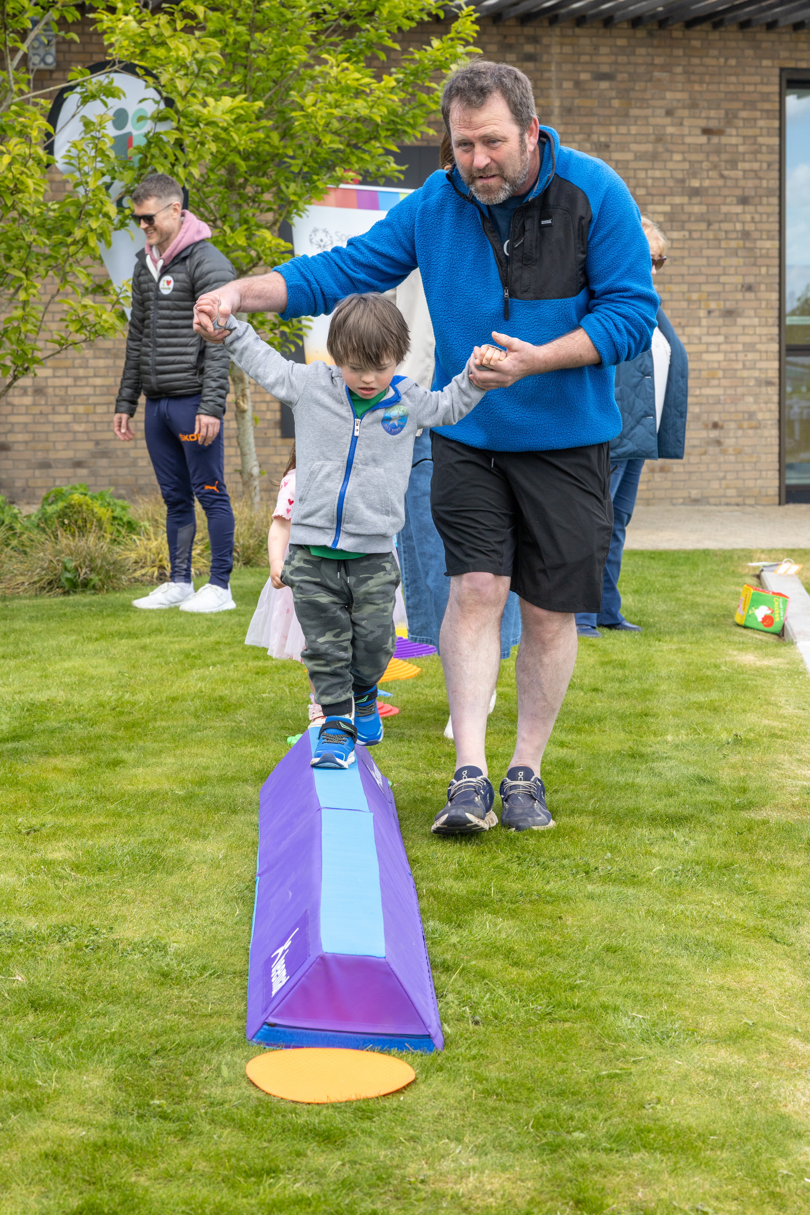 Two people playing on a balancing beam. 